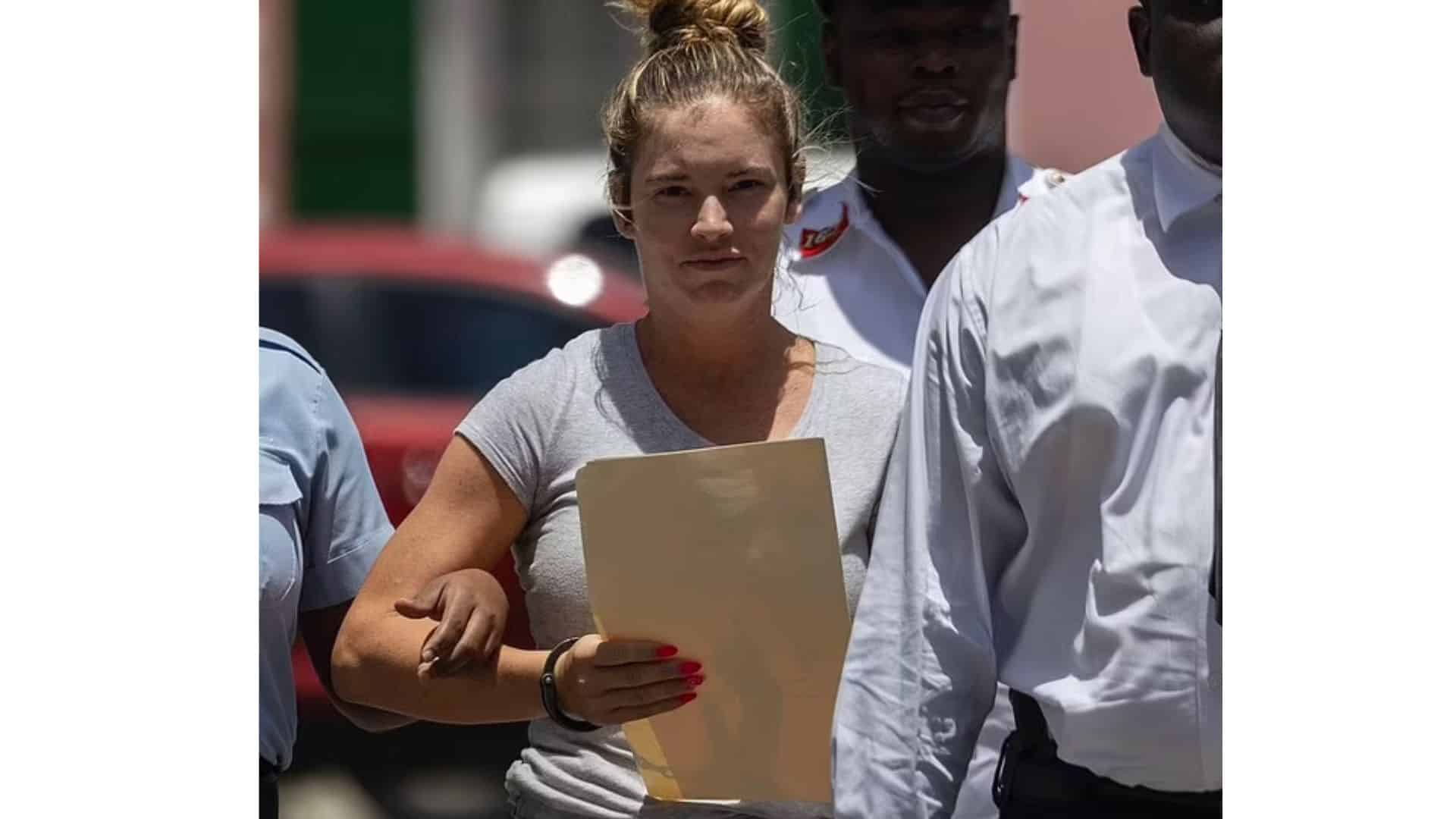 lindsay shiver captured during her court appearance with a document while escorted by officers