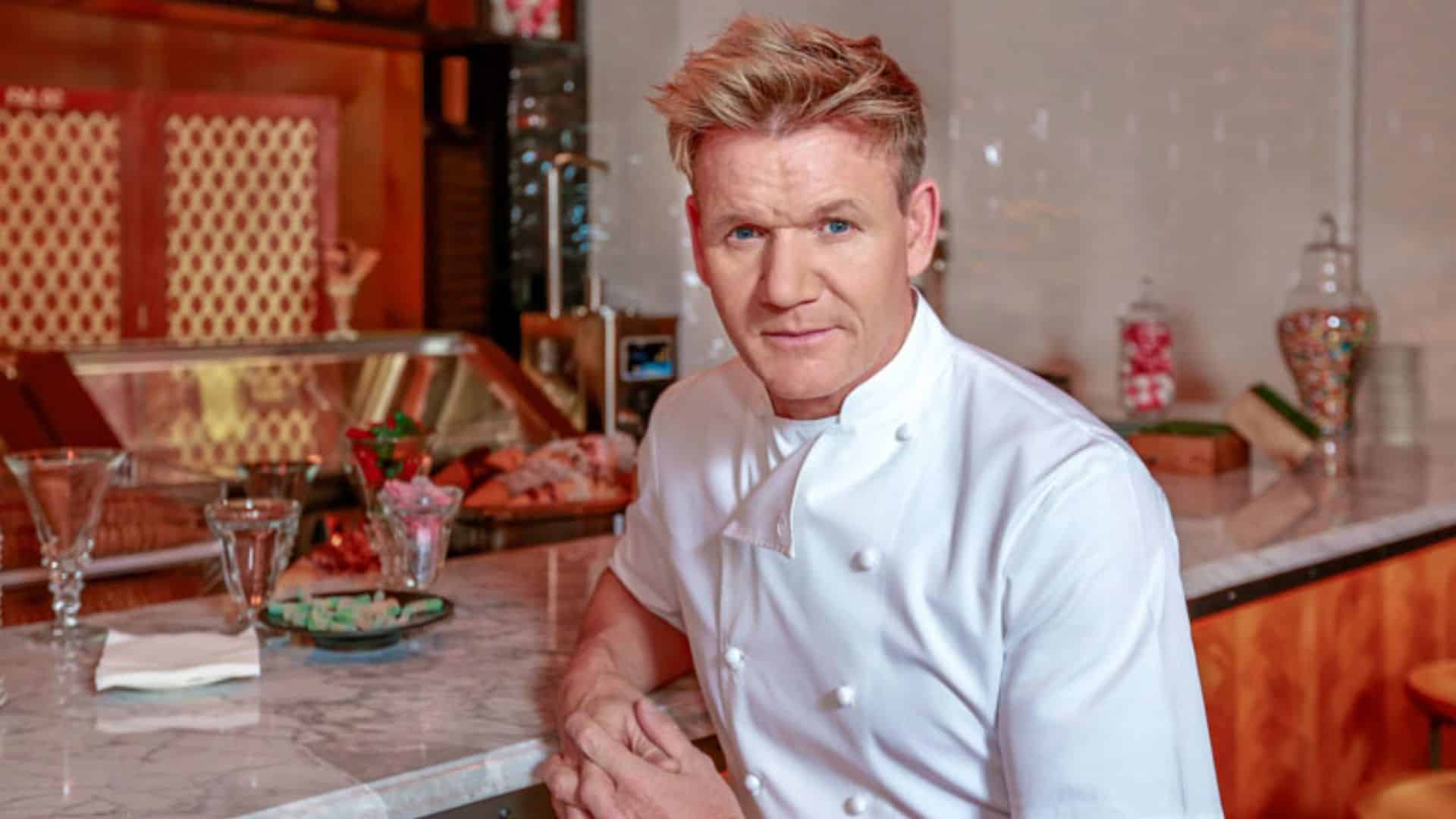 gordon ramsay standing in his restaurant kitchen wearing a chefs jacket.jpeg