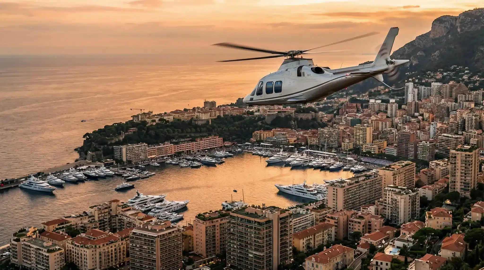 Helicopter flying over coastal city with harbor and luxury yachts at sunset
