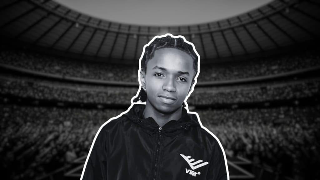 Black-and-white portrait of BabyChiefDoIt the artist before stadium crowd.