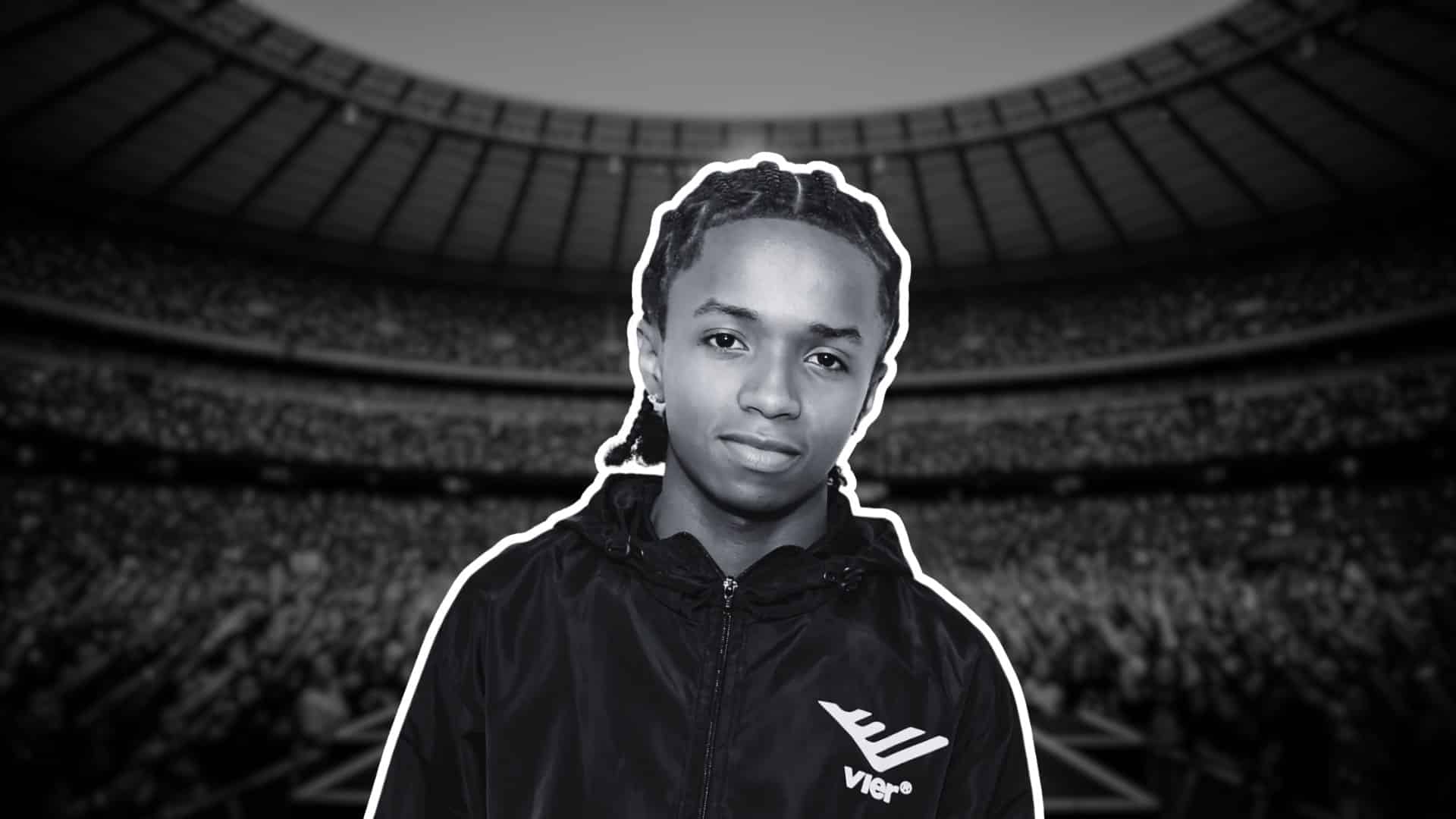 Black-and-white portrait of BabyChiefDoIt the artist before stadium crowd.