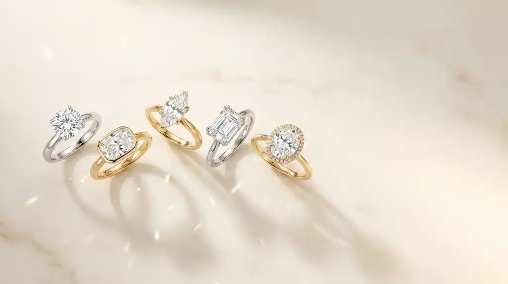 Diamond engagement rings with gold and silver bands on a marble surface