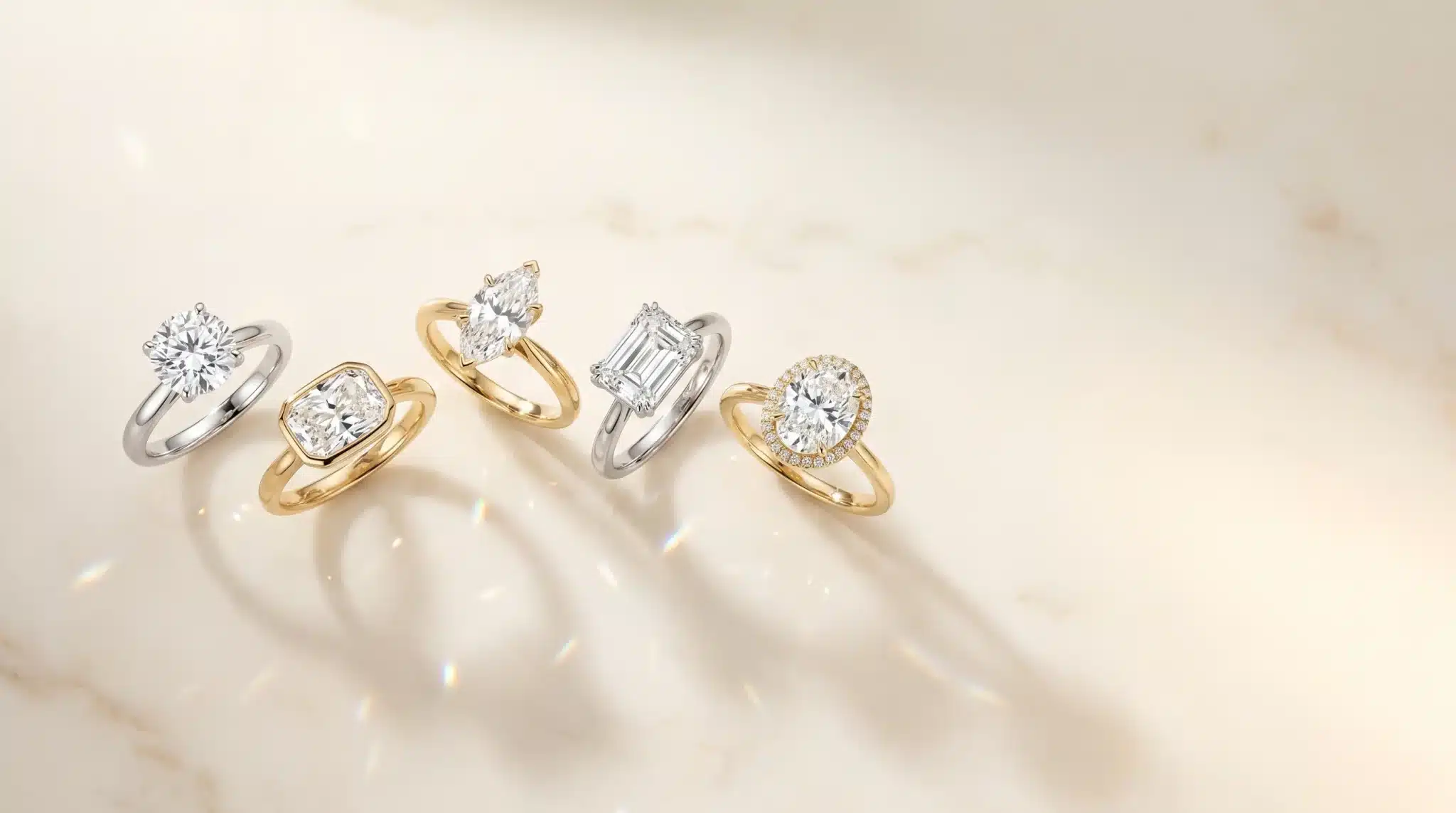 Diamond engagement rings with gold and silver bands on a marble surface
