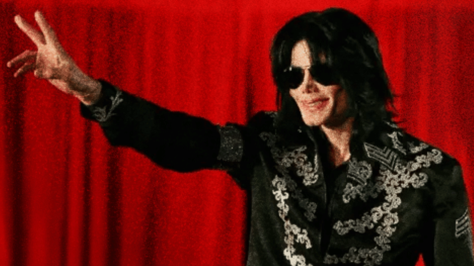 Michael Jackson greeting fans during a public appearance in black outfit.