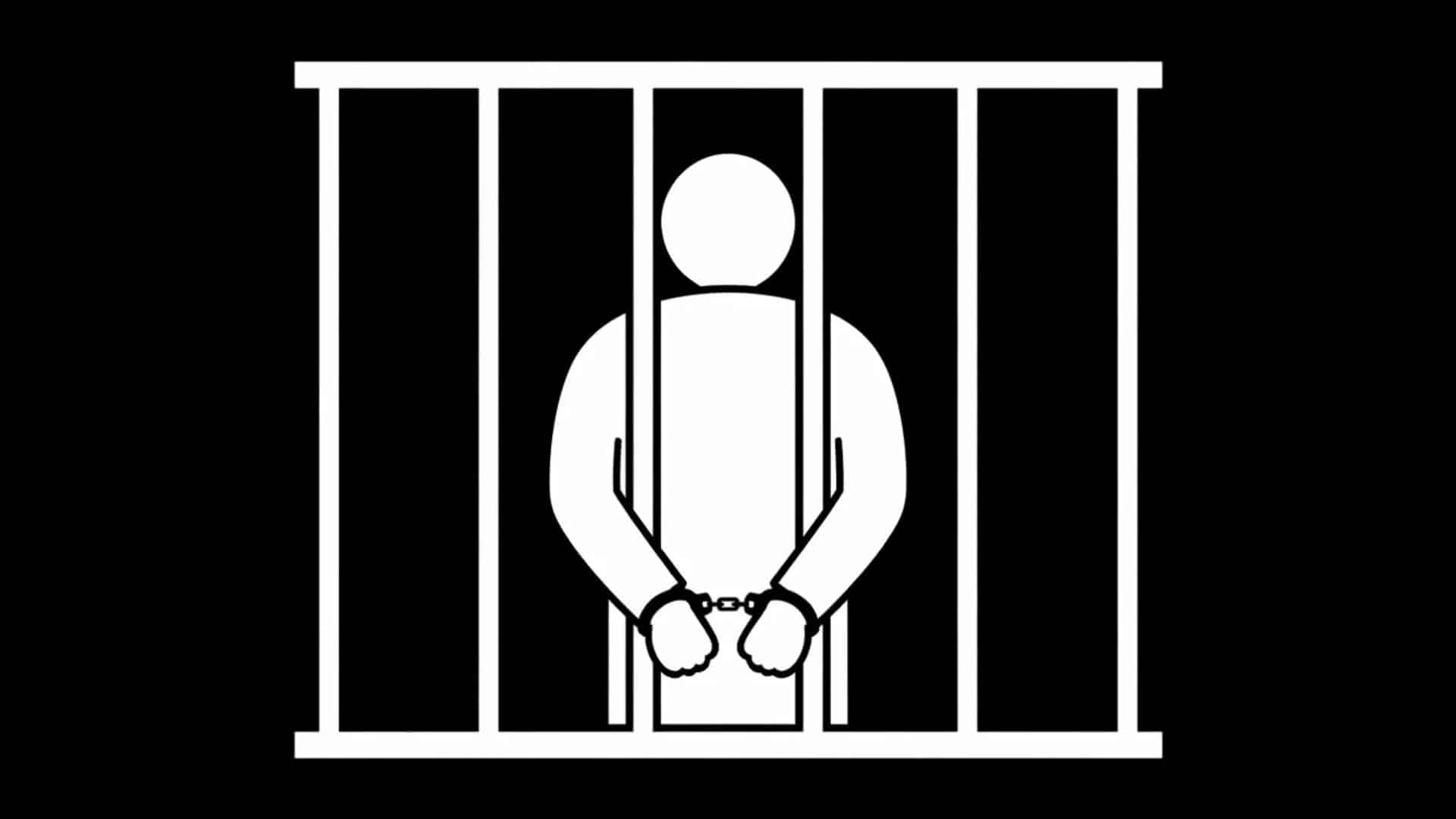 Silhouetted person in handcuffs behind prison bars, representing incarceration and legal consequences.