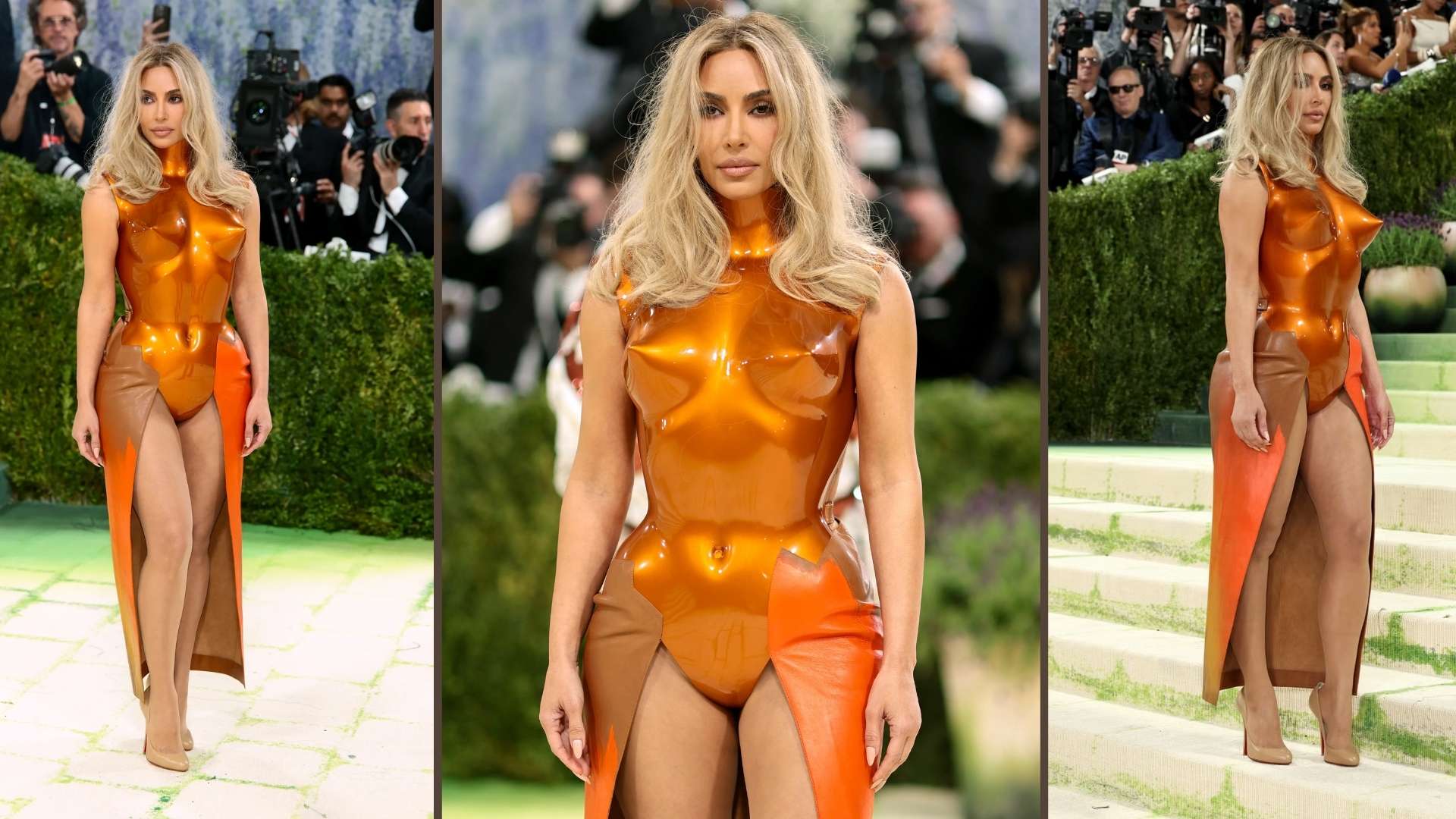 Kim Kardashian in an orange latex dress with bold accents and a side slit at the Met Gala.