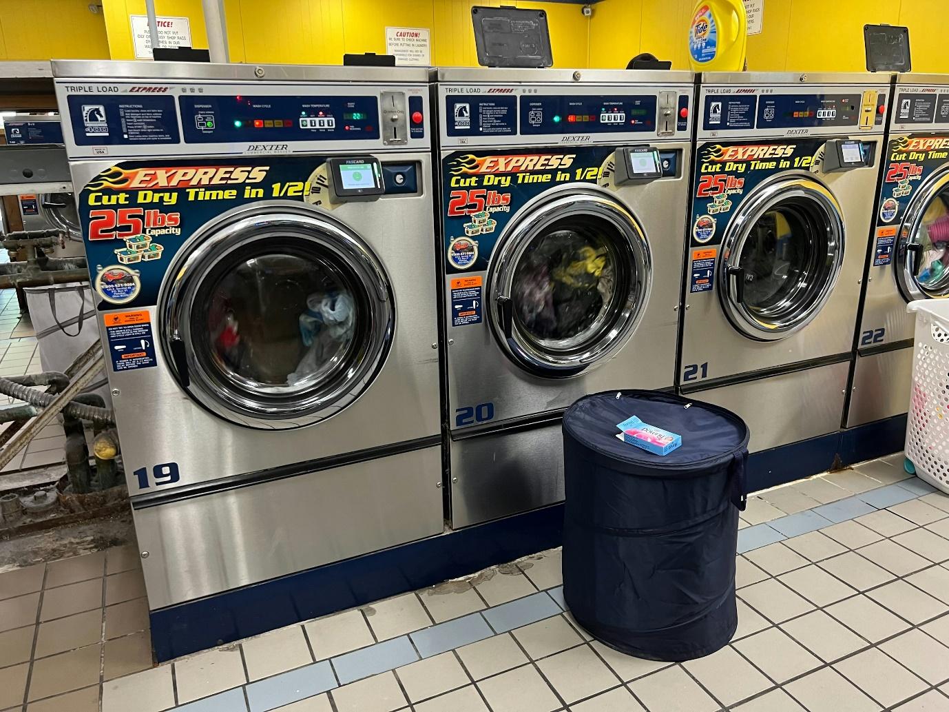 A row of washing machines in a laundry room
