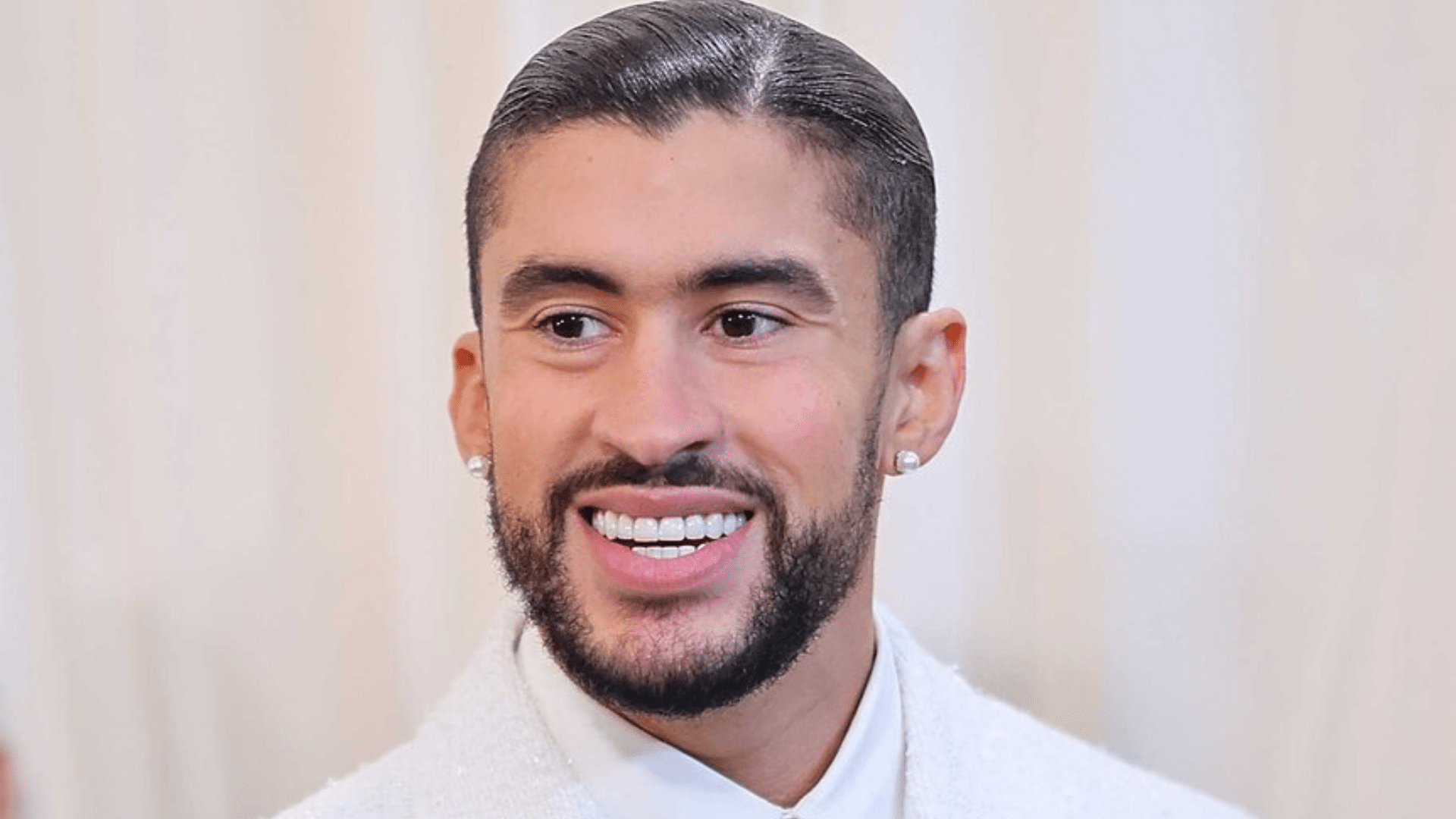 Close-up of Bad Bunny’s smile showing uneven or irregular teeth, highlighting cosmetic dental work that appears less natural or poorly aligned.