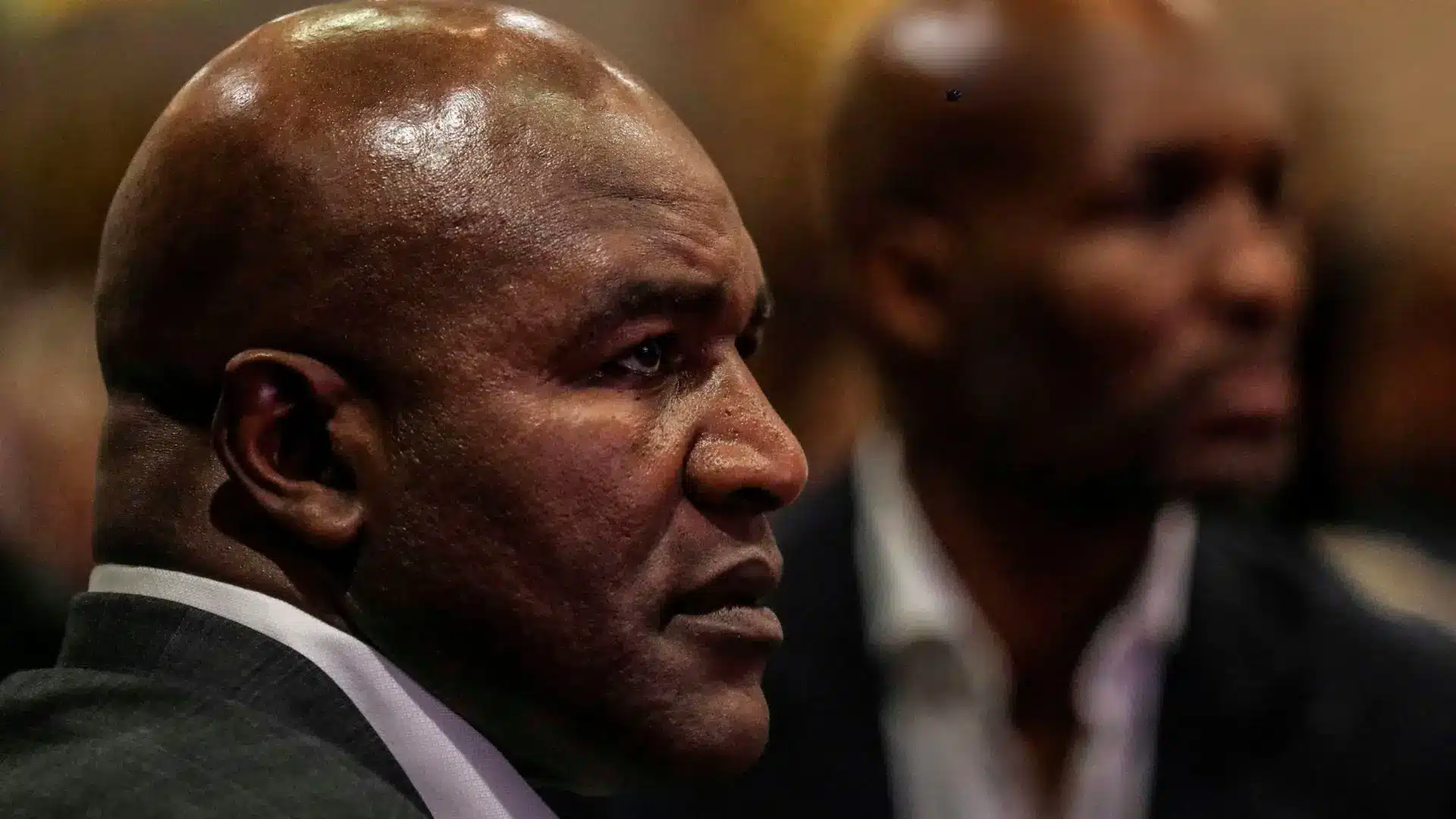 Evander Holyfield speaks with a financial advisor in a private setting, reflecting issues he has spoken about regarding mismanagement and problems with trusted advisors