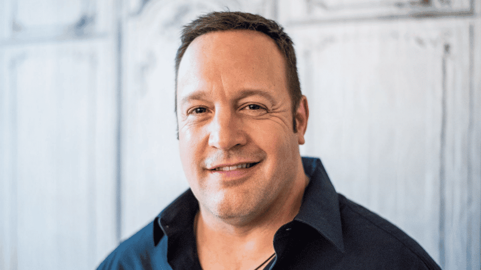 Headshot of Kevin James in a blue collared shirt. Actor's syndication deals boost the kevin james net worth.