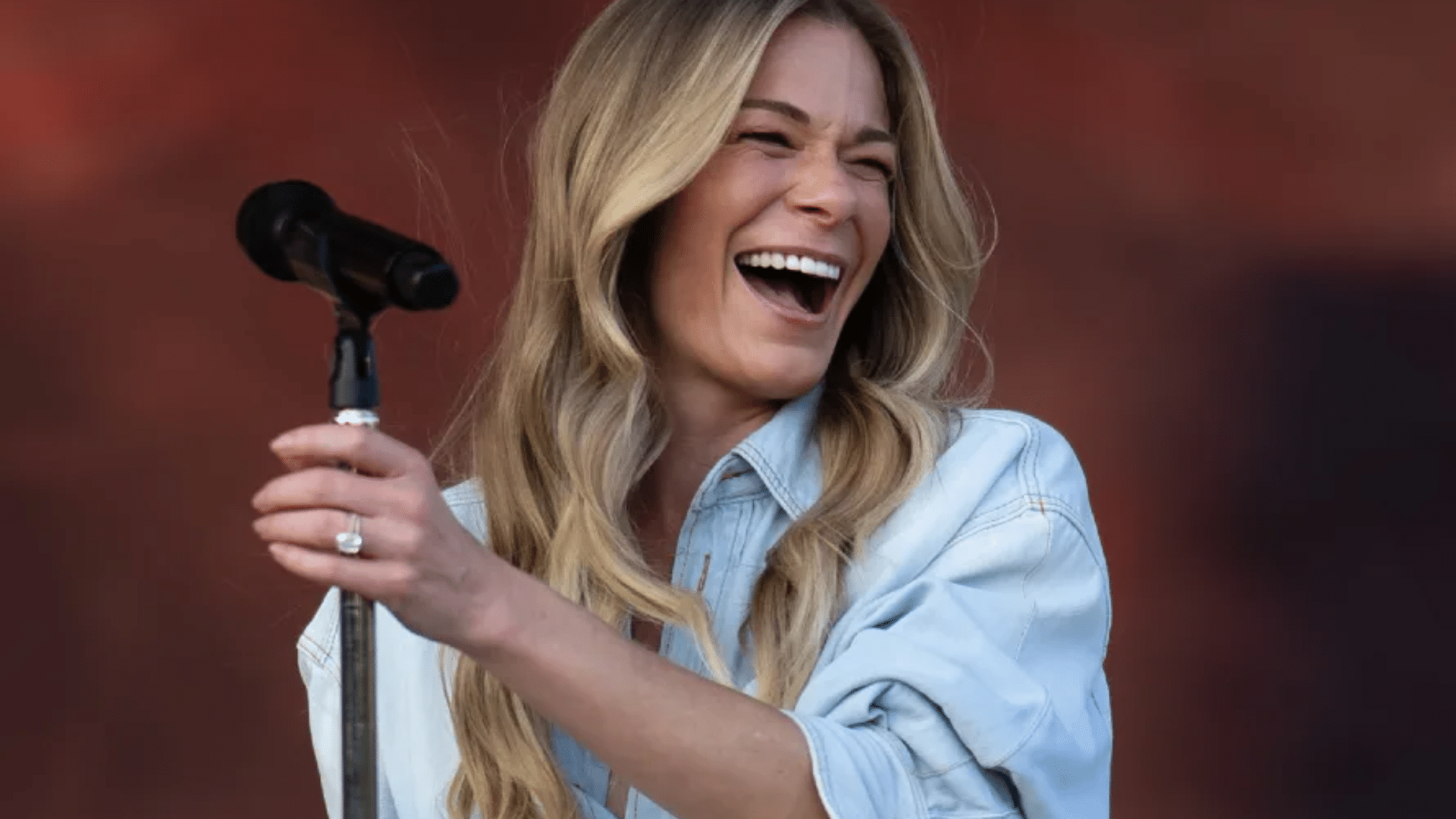 Close-up of LeAnn Rimes’ smile showing teeth that appear uneven and overly bright, highlighting cosmetic veneers that look unnatural or poorly fitted.