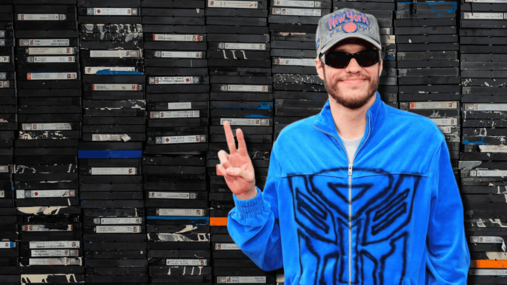 Pete Davidson posing in front of thousands of VHS tapes, showasing his investment in Tapes.