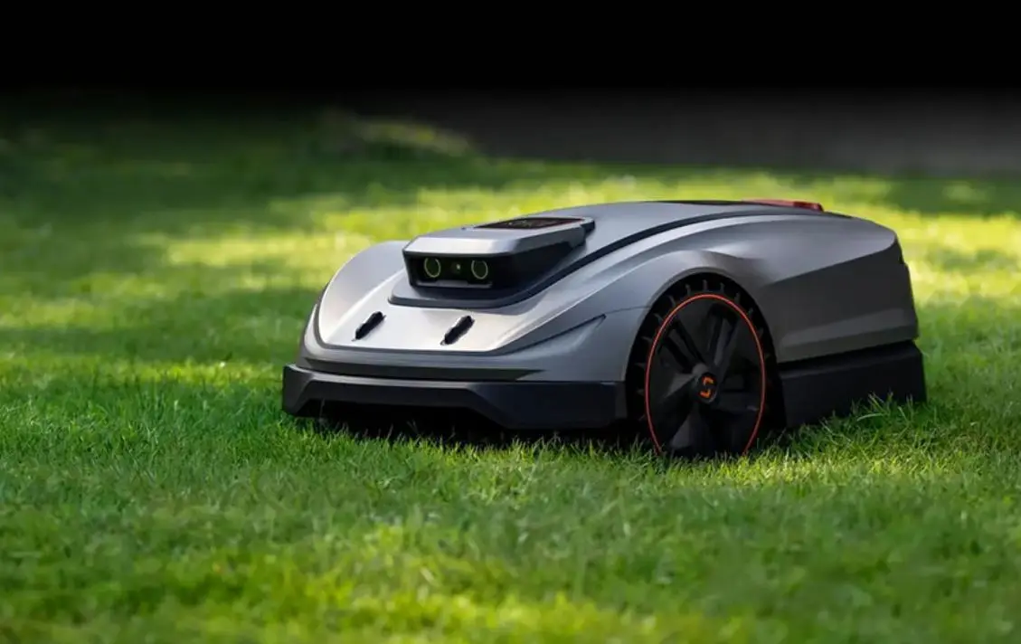 Robotic lawn mower on green grass in a garden setting