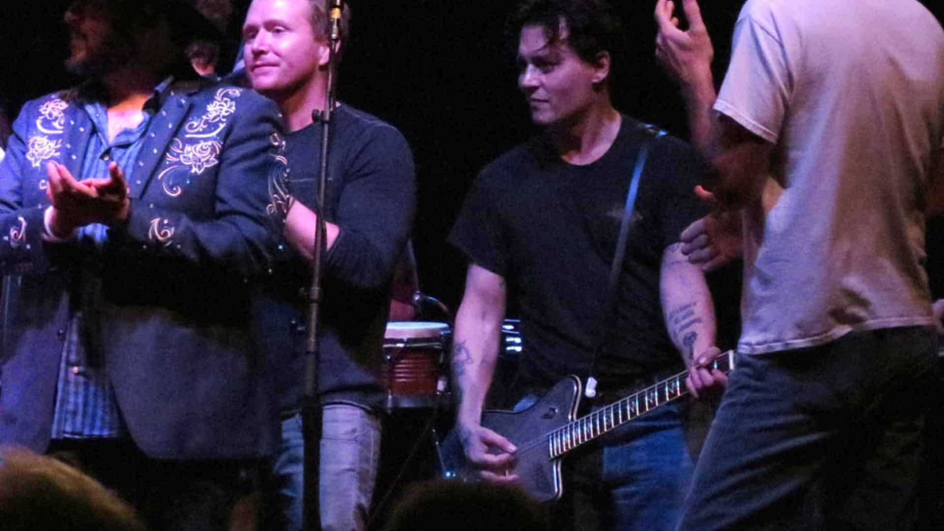 Johnny Depp performing with Willie Nelson on stage at Boston concert