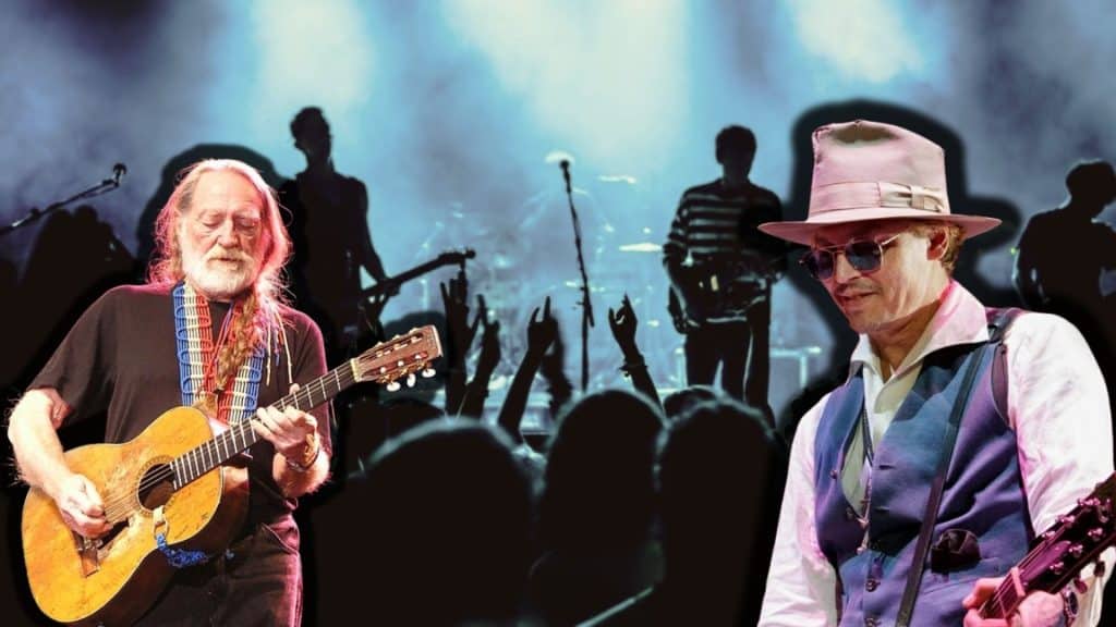 Johnny Depp and Willie Nelson performing live on stage with guitars and band silhouettes behind them.