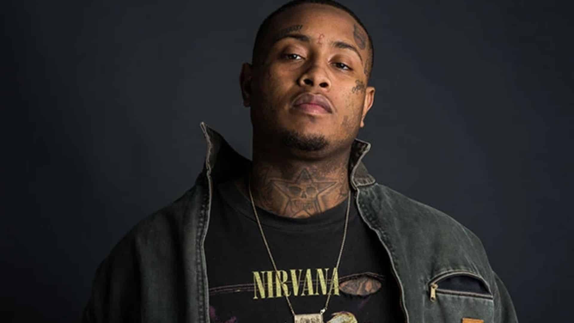 Portrait of Southside, father of Yung Miami’s daughter, posing against dark background.