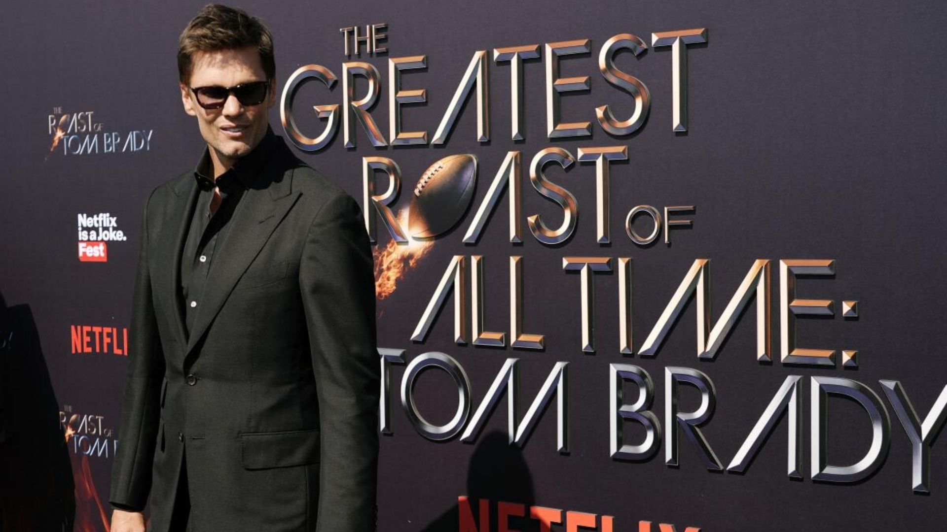 Tom Brady at Netflix roast premiere in front of The Greatest Roast of All Time: Tom Brady backdrop