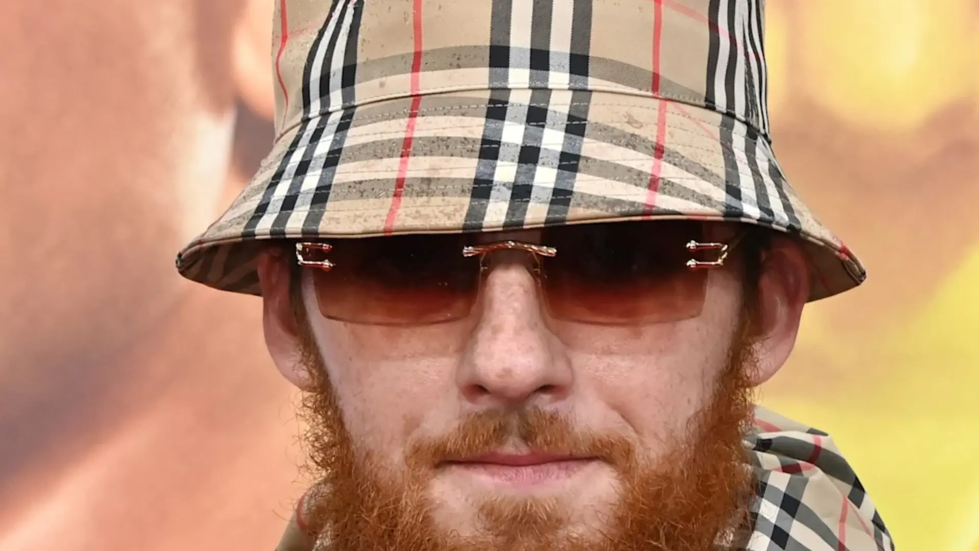 Close-up of Angus Cloud, showing his expressive facial features and intense gaze, with soft lighting highlighting his natural skin texture and emotional depth in the scene.
