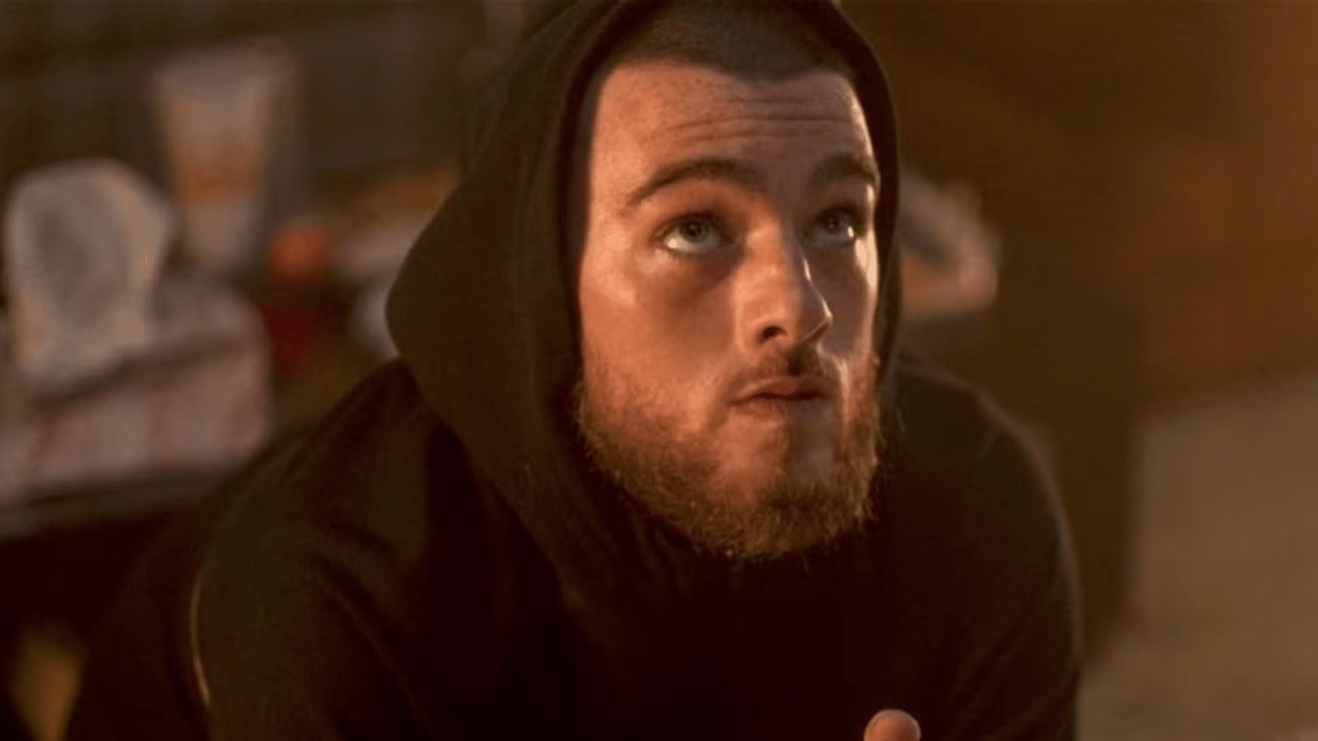 Fez from Euphoria, a medium shot showing him wearing his signature casual streetwear, looking thoughtful, with a dimly lit background capturing the show’s intense and gritty atmosphere.