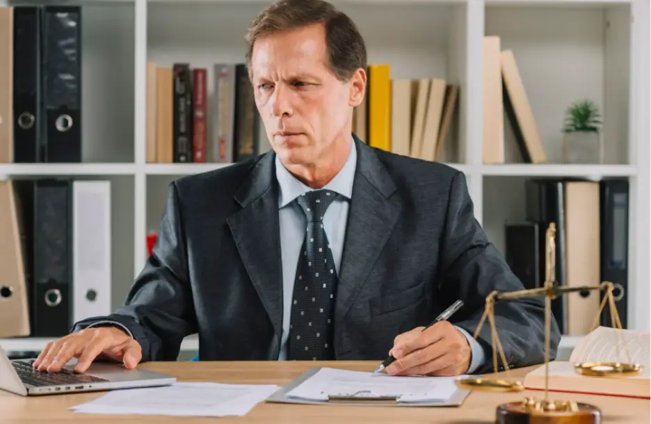 Businessman working at desk with laptop and documents in modern office setting