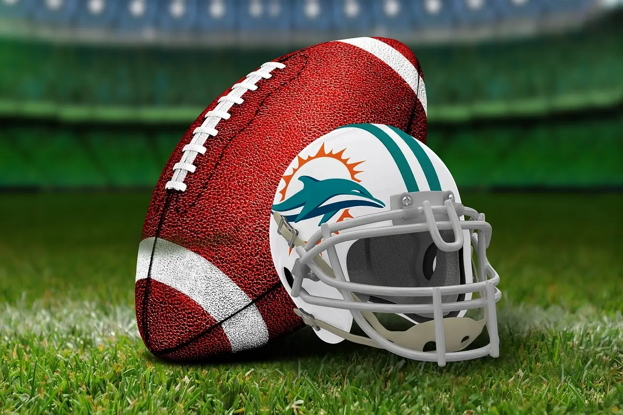 Football and helmet on green grass in a stadium setting